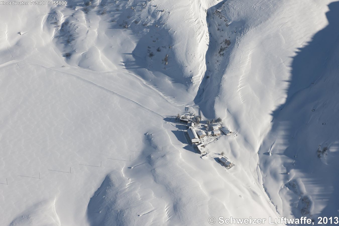 Siedlung Salategnas (976 m.ü.M.) auf der Alp Flix (Position: 2'769'866.54, 1'154'107.13, Blick gegen E). Fläche gegen W der Siedlung: 'Plachet'. Gepfadeter Weg N-wärts zum Berghotel Piz Platta. Starker Geländeeinschnitt Rchtg SE: 'Ava da Savriez'. - Aufnahme am 18. Januar 2013